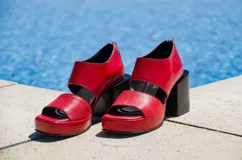 Sandalias rojas de cuero con plataforma y taco bloque negros. Cierre con cremallera en el talón.