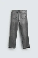 Pantalón de jean celeste de corte flare, con tiro medio, cinco bolsillos, cierre frontal con cremallera y botón, y bajo con acabado irregular.