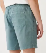 Bermuda celeste de sarga con cintura elástica ajustable con cordón, bolsillos laterales y traseros, y etiqueta con logo en la parte inferior.