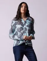 Camisa de gasa estampada a rayas verticales de color celeste, blanco, naranja y marrón. Tiene cuello con solapa, escote en V, abertura central con botones, bolsillo aplicado en el pecho y terminación anudada en la parte delantera.