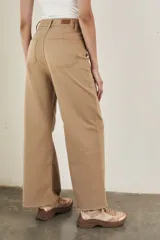 Pantalón wide leg color beige, de tiro alto, ligeramente ajustado en cintura y con ruedo desflecado.