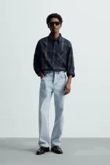 Pantalón de jean celeste de corte recto, con cinco bolsillos, efecto lavado y cierre frontal con botones.