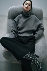 Sweater gris de lana con cuello alto, corte oversize y mangas largas acampanadas.