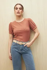 Remera color ladrillo de tejido de punto acanalado, con cuello redondo y mangas cortas abullonadas.