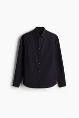 Camisa de manga larga color negro con finas rayas verticales, cuello inglés, tapeta clásica, bolsillo superior abierto, canesú con pliegue de caja en la espalda y bajo redondeado.