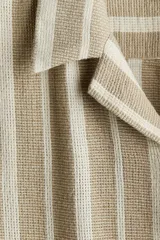 Camisa de manga corta con cuello resort y cierre frontal con botones. Diseño a rayas verticales en tonos beige y blanco.