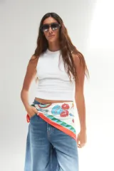 Pañuelo cuadrado de tela fina color blanco con estampado de motivos gastronómicos y borde con diseño geométrico en rojo, verde y celeste.