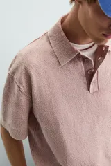 Polo de hombre color rosa, corte relaxed fit, tejido de punto con textura bouclé y mezcla de algodón. Tiene cuello solapa, cierre frontal con botones, manga corta y acabados en rib.