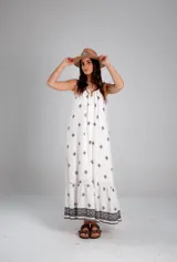 Vestido blanco con estampado de cruces negras, sin mangas y corte holgado.