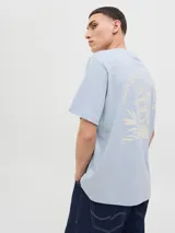 Remera celeste con estampado en la espalda que incluye texto y una imagen de una persona con un tocado.