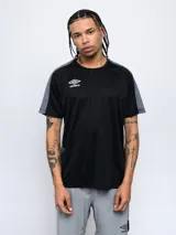 Remera deportiva negra de manga corta con cuello redondo. Presenta paneles laterales y en las mangas con un estampado texturizado en gris. Logo Umbro blanco bordado en el pecho.