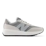 Championes New Balance modelo 370, color gris claro y gris medio, con suela blanca gruesa y detalles en gamuza y malla. Presentan el logo 'N' en el lateral y la inscripción 'balance' en el talón.