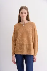 Sweater color ocre con diseño floral en jacquard y lurex a tono, escote redondo y mangas largas.