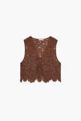 Top chaleco marrón de crochet con escote en pico y cierre frontal con lazos.