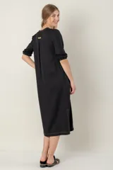 Vestido azul de lino, corte recto, largo midi, escote en V, manga corta, bolsillos laterales y tajos en los laterales.