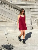 Vestido corto dorado de tejido de punto con breteles finos y escote en V.
