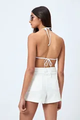 Short de jean color beige, con calce medio, bolsillos funcionales y tajos pequeños en el ruedo.