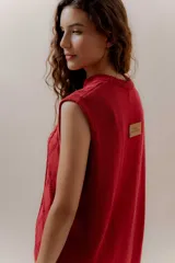 Vestido corto tejido color beige, sin mangas y con cuello redondo.