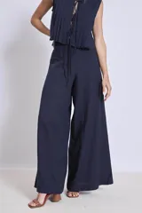 Pantalón ancho de tiro alto color rojo, con pliegues verticales en la parte superior y caída fluida.