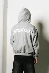 Hoodie gris con cierre, corte regular fit y estampa en el frente.