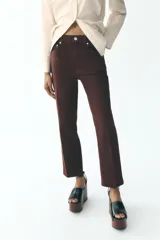 Jeans de tiro alto color marrón, corte slim fit y bootcut, con cinco bolsillos y cierre frontal con cremallera y botón.