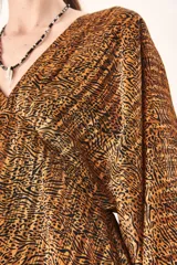 Vestido corto con estampado animal print en tonos marrones y negros, escote en V y mangas largas abullonadas.