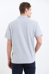 Remera manga corta verde con cuello polo y tapeta con botones.