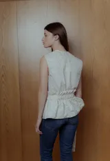 Top sin mangas color crema con estampado floral y lazo en la cintura.