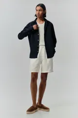 Short blanco de lino y algodón, con corte relajado, cintura elástica con cordón ajustable, bolsillos laterales y bolsillo trasero insertado.