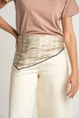 Pañuelo cuadrado de seda color beige con lunares blancos y borde negro.