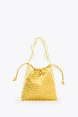 Bolso mini tipo saco con cuerpo de abalorios amarillos, asa de hombro de cuentas y asa bandolera de cadena. Incluye bolsita interior con cierre fruncido.