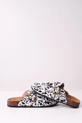 Zueco abierto con estampado animal print blanco y negro, hebilla metálica dorada y plantilla anatómica.