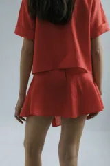 Minifalda de lino color coral con cierre lateral con botones de madera.