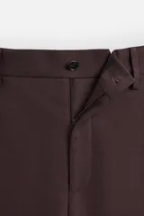 Pantalón de vestir color marrón oscuro, de corte recto, con bolsillos laterales y traseros de doble vivo. Cierre frontal con cremallera y botón.