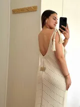 Vestido largo tejido con hilo de algodón y lurex color verde oliva. Silueta trapecio, escote en V, tiras regulables con borlas, espalda abierta y tajos laterales.