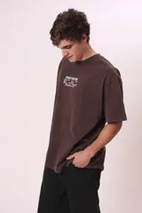 Camiseta de manga corta, color gris oscuro con efecto lavado, corte oversize y cuello redondo. Presenta texto estampado en blanco en el pecho que dice "CREW MEMBER".