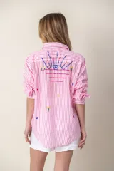 Camisa blanca de manga larga con bordados de motivos playeros.