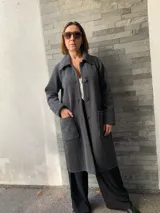 Saco largo gris oscuro tejido en lana merino, con cuello, puños y bolsillos de tejido con diseño de espiga en tono gris claro.