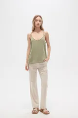 Musculosa color crema de bretel fino con apliques de cadena en los breteles y escote en V.