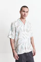 Camisa de manga corta con cuello pijama y estampado abstracto en tonos celeste, beige y blanco.
