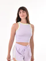 Musculosa lila con cuello y sisas en amarillo flúor, de corte crop y tejido acanalado.