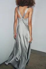 Vestido largo gris de satén con escote en V, tirantes finos y aberturas laterales.
