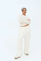 Pantalón deportivo de algodón color crudo, corte holgado, cintura elástica con cordón ajustable, bolsillos laterales y bajos sin rematar.