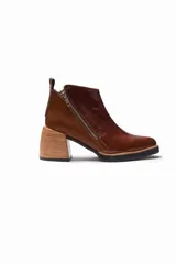 Bota corta de cuero color borgoña con textura de piel de reptil, cierre lateral con cremallera y tacón geométrico de madera clara.