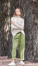 Pantalón babucha verde de cuerina con bolsillos laterales y cinturón fino marrón.