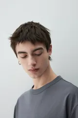 Remera gris de punto pesado con cuello redondo ribeteado, hombros caídos y bajo recto. Corte holgado confeccionada con tejido funcional COOLMAX®, una fibra exclusiva de poliéster de secado rápido que elimina la humedad y regula la temperatura corporal.