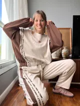 Pantalón de jogging color crema con cintura elastizada y cordón ajustable. Presenta una franja lateral con estampado animal print.