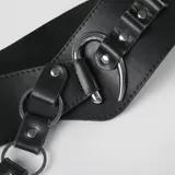 Cinturón ancho de cuero sintético negro con cadena de eslabones plateados y detalle de tachas.