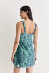 Vestido corto de fiesta, cubierto de lentejuelas plateadas, con escote en V y flecos de tul color crema.