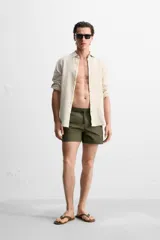 Short de baño negro de tejido técnico, con cintura elástica ajustable con cordón, bolsillos laterales y bolsillo trasero.